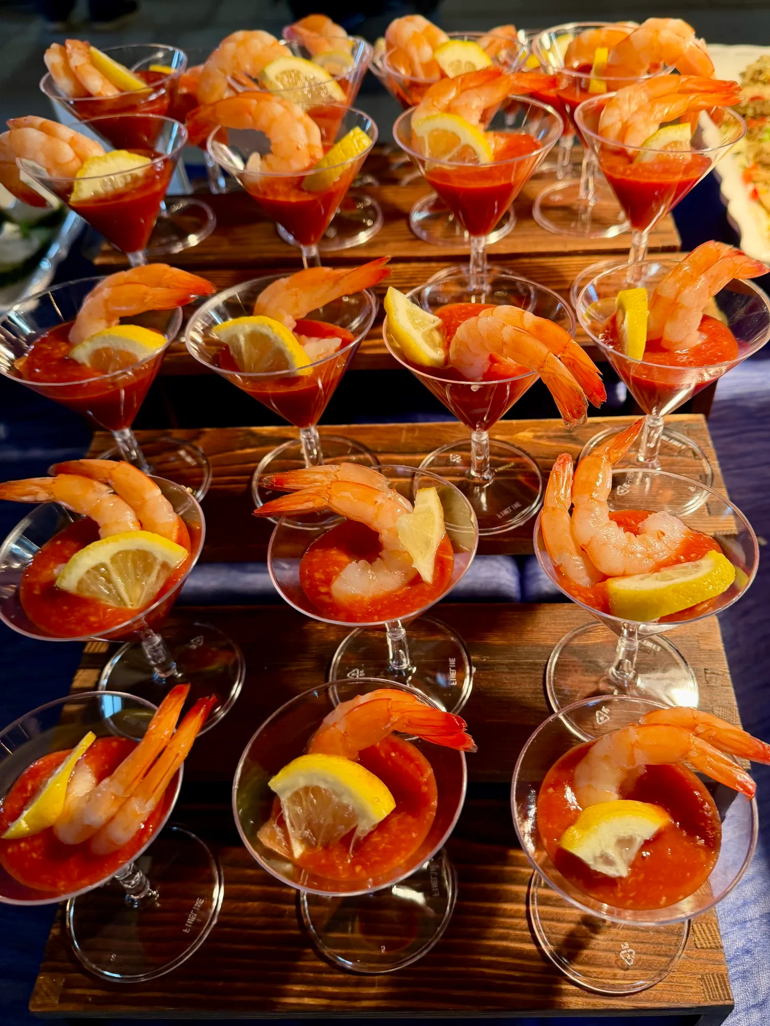 Shrimp cocktail served in individual martini glasses with lemon.