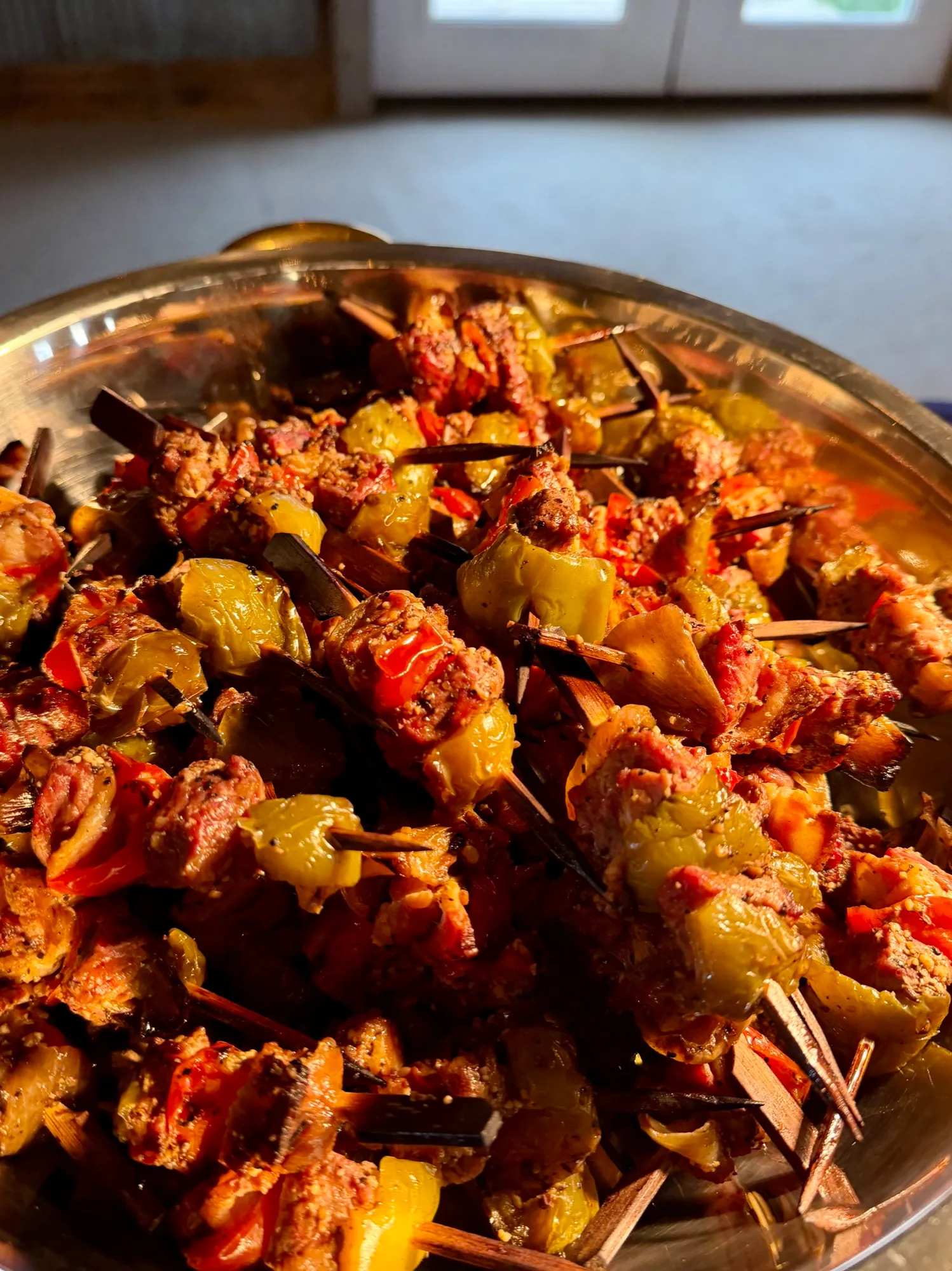 Skewered chicken and vegetable kabobs stacked on a serving tray.