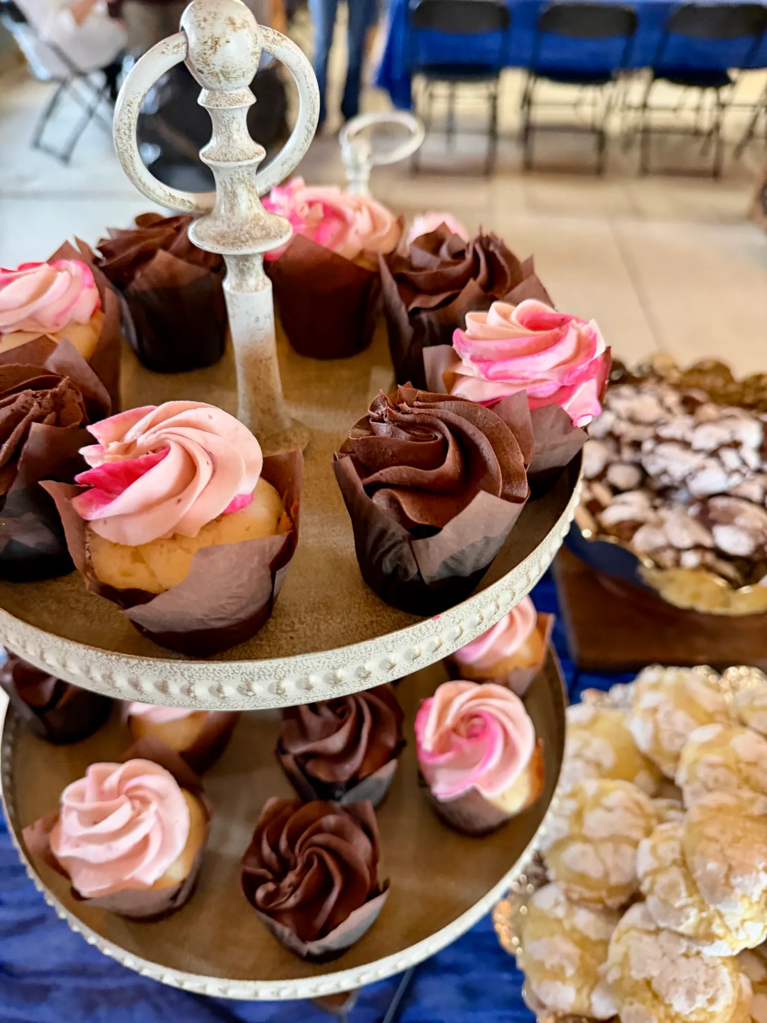 Cupcakes with pink and chocolate frosting on a tiered stand.