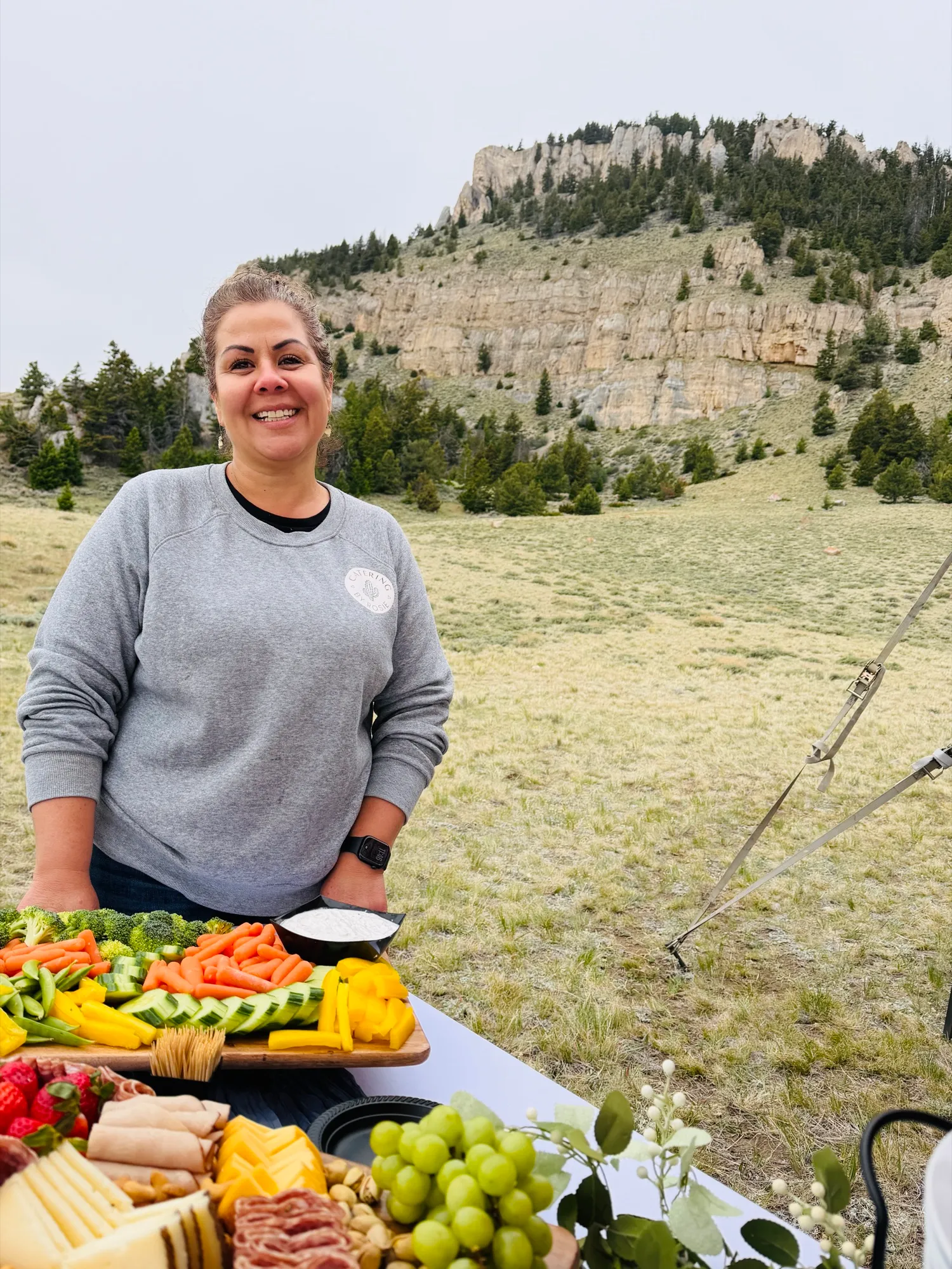 Rosie Roberson behind a table of fresh trays, the Wyoming hills behind her.